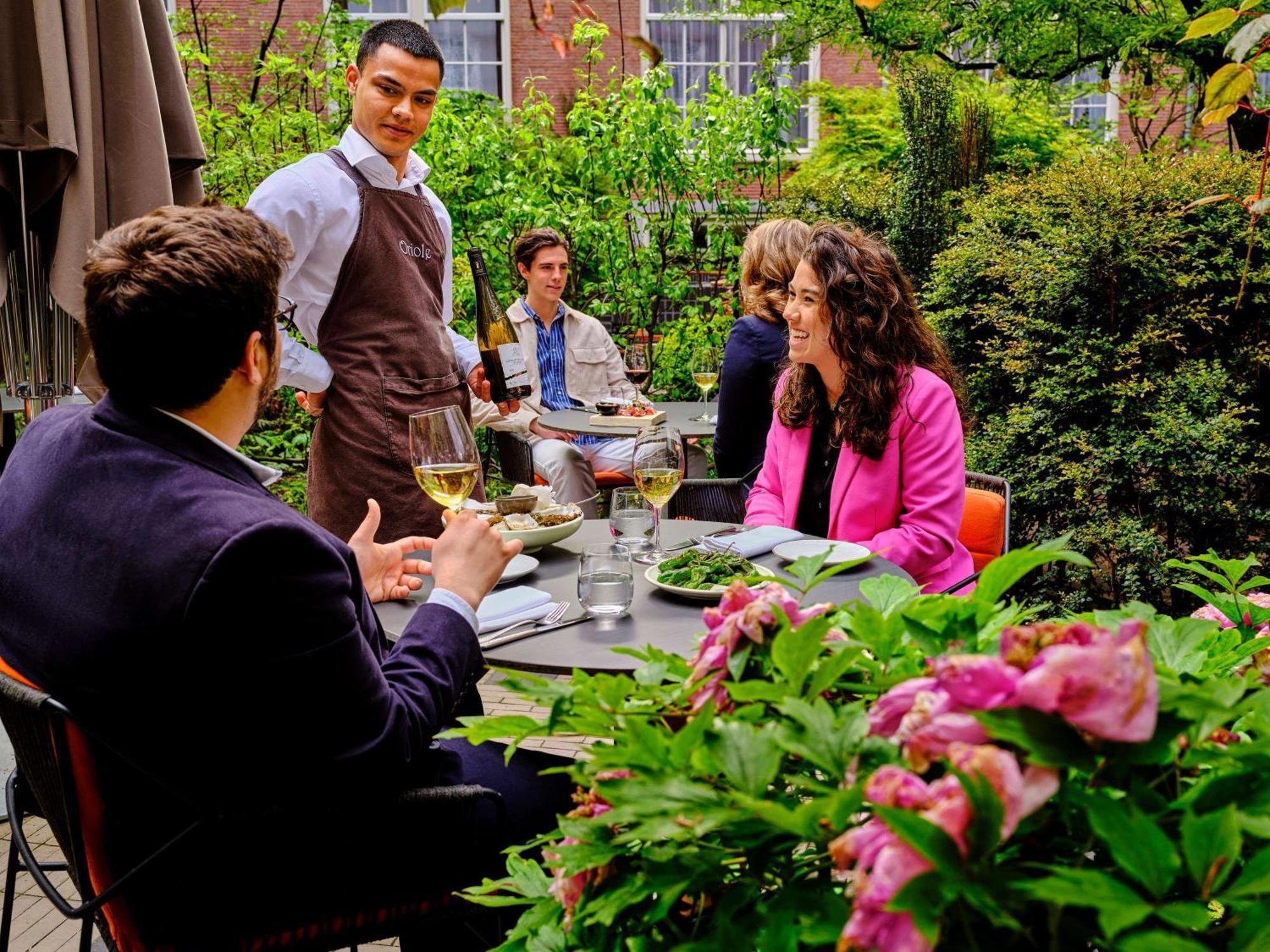Hotel Sofitel Legend The Grand Amsterdam Esterno foto A waiter serving guests at a restaurant
